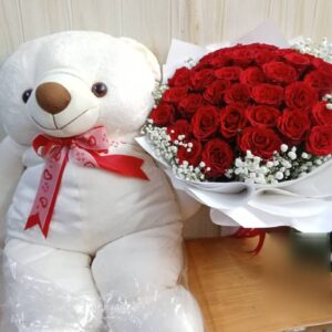 Teddy bear and bouquet of red roses