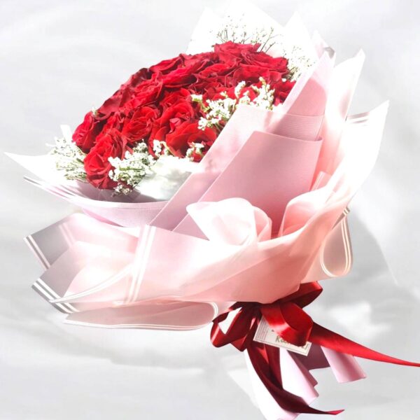 25 round red roses, pink paper