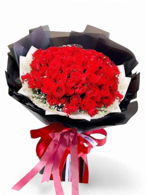 A bouquet of 51 red roses decorated with black paper.
