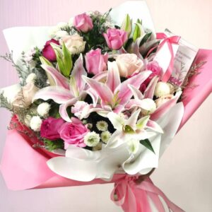 A bouquet of pink and white lilies mixed with other pink-toned flowers
